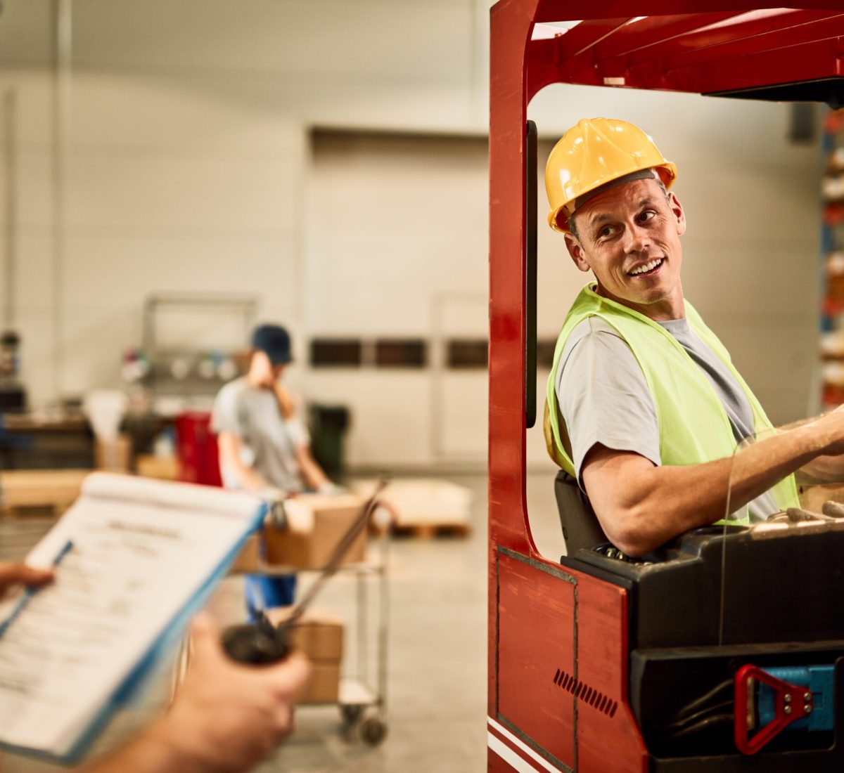 Happy forklift driver communicating with dispatcher in industrial warehouse.
